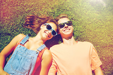 Image showing happy teenage couple lying on grass at summer