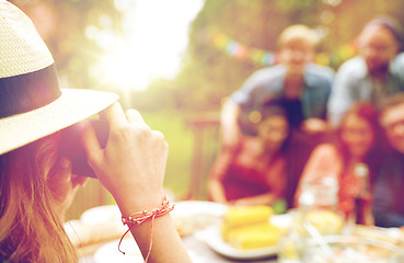 Image showing woman photographing friends at summer garden party