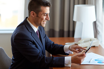 Image showing businessman with tablet pc working at hotel room