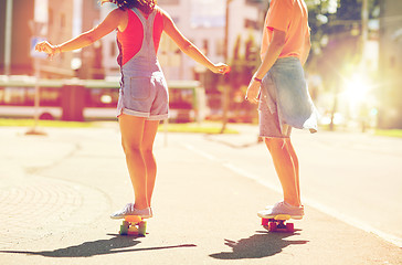 Image showing teenage couple riding skateboards on city street