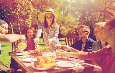 Image showing happy friends having dinner at summer garden party