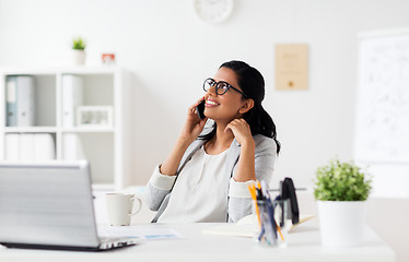 Image showing businesswoman calling on smartphone at office