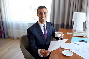 Image showing businessman with papers drinking coffee at hotel