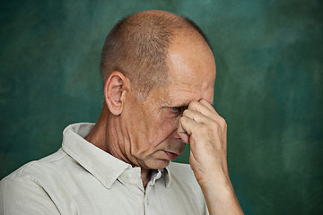 Image showing Worried mature man touching his head.