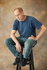 Image showing Worried mature man sitting at studio