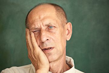 Image showing Worried mature man touching his head.