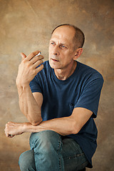 Image showing Worried mature man sitting at studio