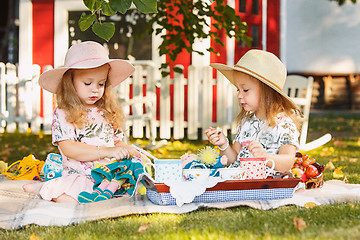 Image showing Two little girls sitting on green grass