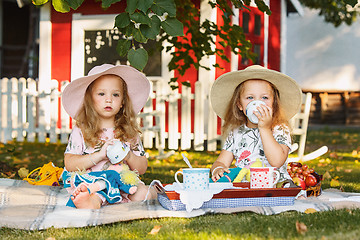 Image showing Two little girls sitting on green grass