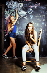 Image showing back to school after summer vacations, two teen girls in classroom with blackboard painted