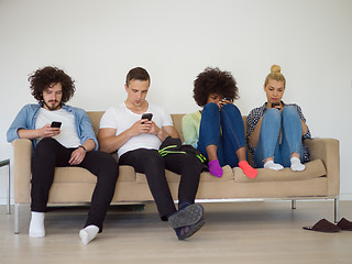 Image showing multiethnic group of young people staring at smartphone