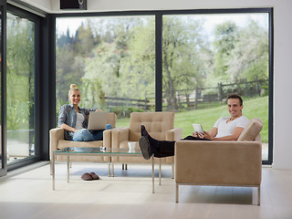 Image showing couple relaxing at  home with tablet and laptop computers