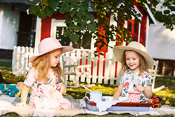 Image showing Two little girls sitting on green grass