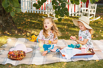 Image showing Two little girls sitting on green grass