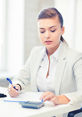 Image showing businesswoman with notebook and calculator