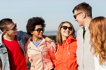 Image showing happy teenage friends in shades talking on street