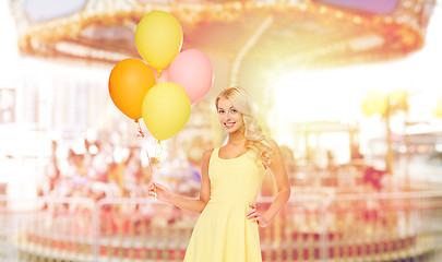 Image showing happy woman with air balloons over carousel