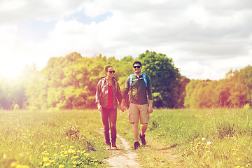 Image showing happy couple with backpacks hiking outdoors