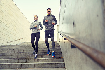 Image showing happy couple running downstairs in city