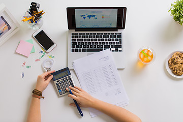 Image showing hands with calculator and papers at office table