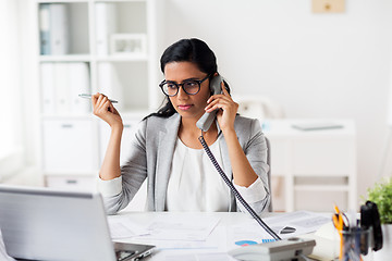 Image showing businesswoman calling on phone at office