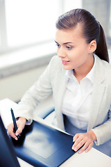 Image showing businesswoman with drawing tablet in office