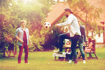 Image showing happy friends playing football at summer garden