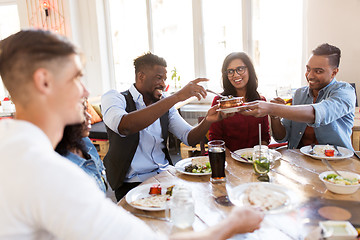 Image showing happy friends eating at restaurant