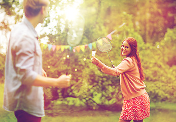 Image showing happy friends playing badminton at summer garden