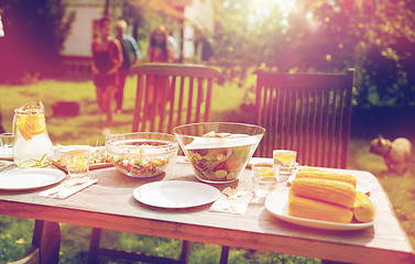 Image showing people coming to table with food at summer garden