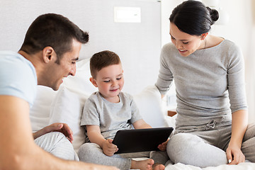 Image showing happy family with tablet pc in bed at home