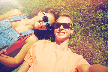 Image showing happy teenage couple taking selfie on summer grass