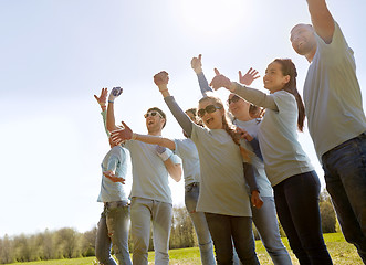 Image showing group of volunteers celebrating success in park