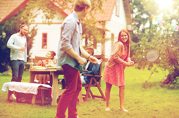 Image showing happy friends playing badminton at summer garden