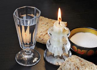 Image showing Shot glass, bread and candlestick