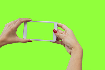 Image showing Young girl hand holding mobile smart phone on green screen