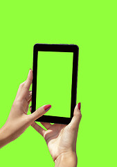 Image showing Young girl hand holding a tablet on green screen