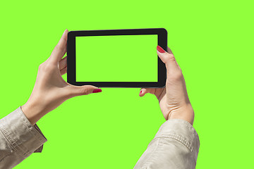 Image showing Young girl hand holding a tablet on green screen