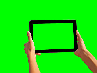 Image showing Young girl hand holding a tablet on green screen