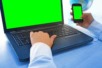 Image showing Women hands working on laptop and smart phone in office on green