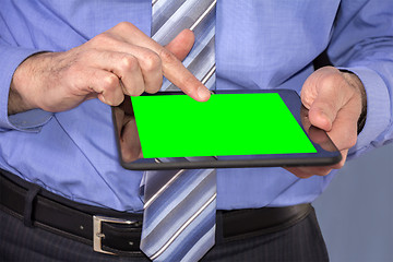 Image showing Young business man working on a digital tablet on green screen
