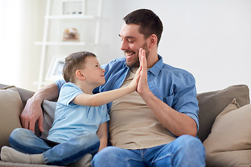 Image showing father and son doing high five at home