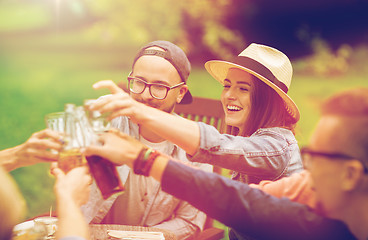 Image showing happy friends clinking glasses at summer garden