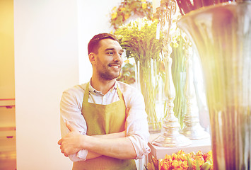 Image showing happy smiling florist man standing at flower shop