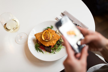 Image showing woman with smartphone photographing food at cafe