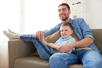 Image showing happy father and son sitting on sofa at home