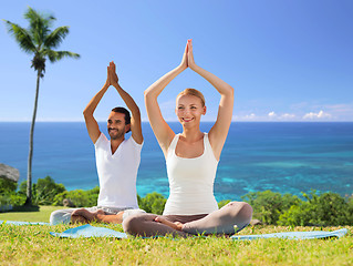 Image showing couple doing yoga in lotus pose outdoors