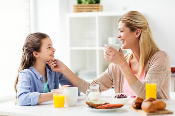 Image showing happy family having breakfast at home kitchen