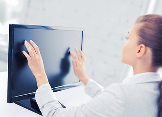 Image showing smiling businesswoman with touchscreen in office