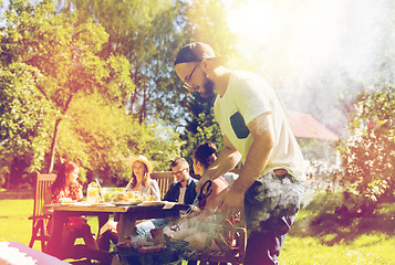 Image showing man cooking meat on barbecue grill at summer party